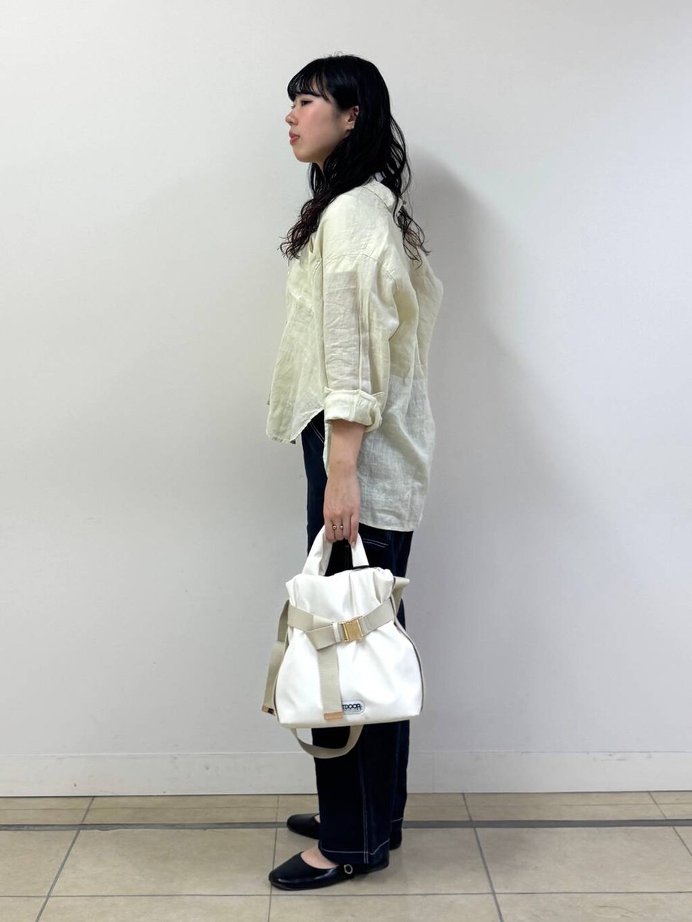 イエロー系のシャツ/ブラウス、ブルー系のその他パンツ、ホワイト系のトートバッグを着用したレディースの春コーディネートの2枚目の写真