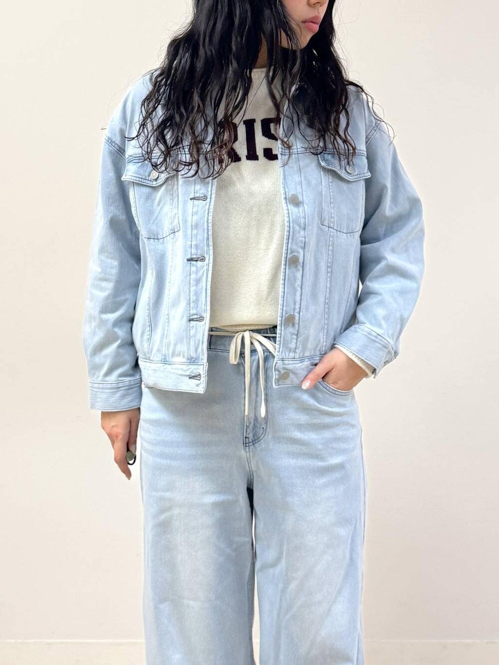 ホワイト系のニット/セーター、ブルー系のデニムパンツ、ブルー系のデニムジャケットを着用したレディースの冬コーディネートの3枚目の写真