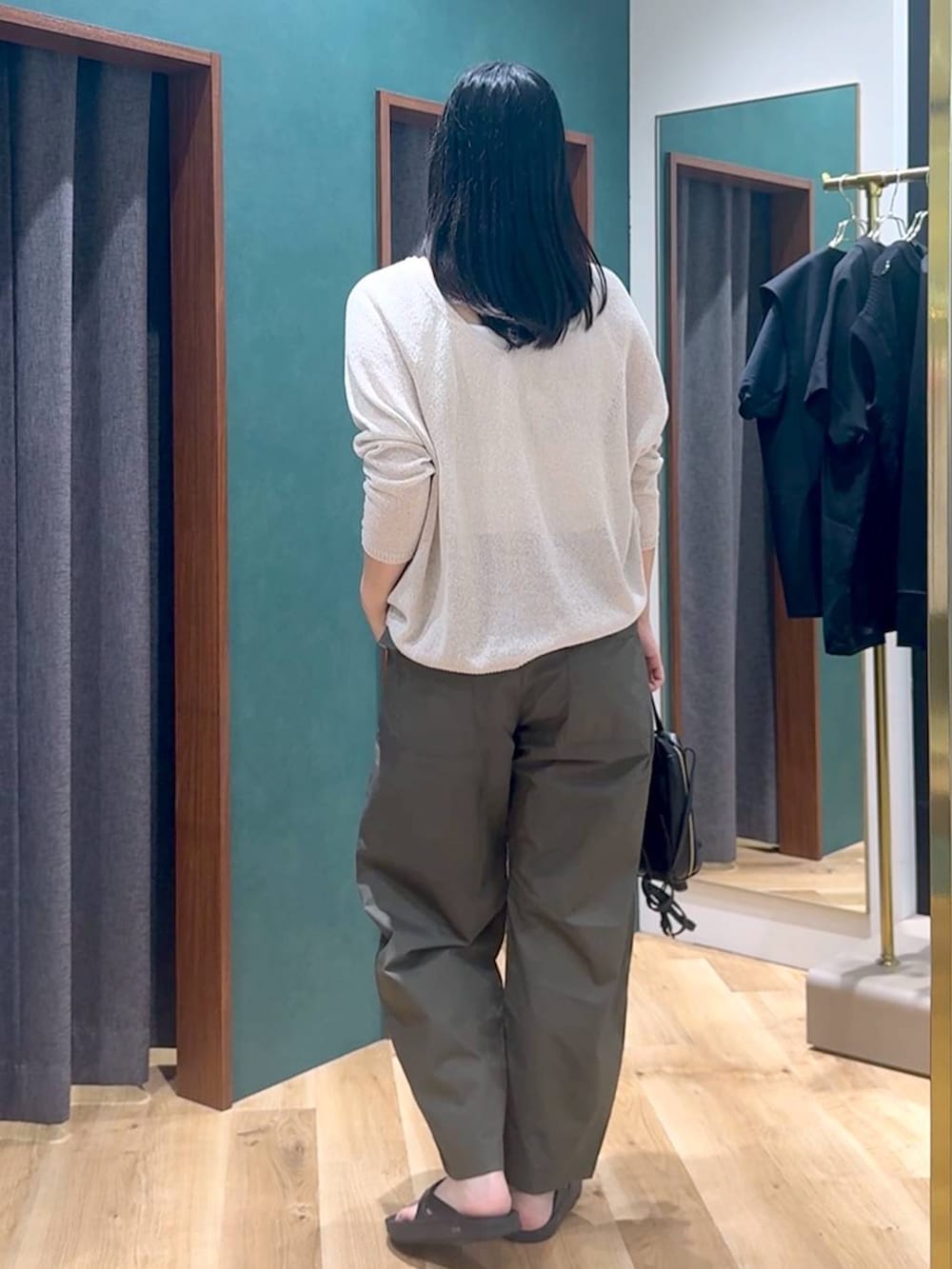 ブラック系のショルダーバッグ、ホワイト系のニット/セーター、グリーン系のカーゴパンツを着用したレディースの夏コーディネートの3枚目の写真
