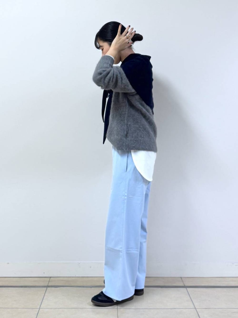グレー系のニット/セーター、ホワイト系のTシャツ/カットソー、ブルー系のその他パンツを着用したレディースの秋コーディネートの2枚目の写真