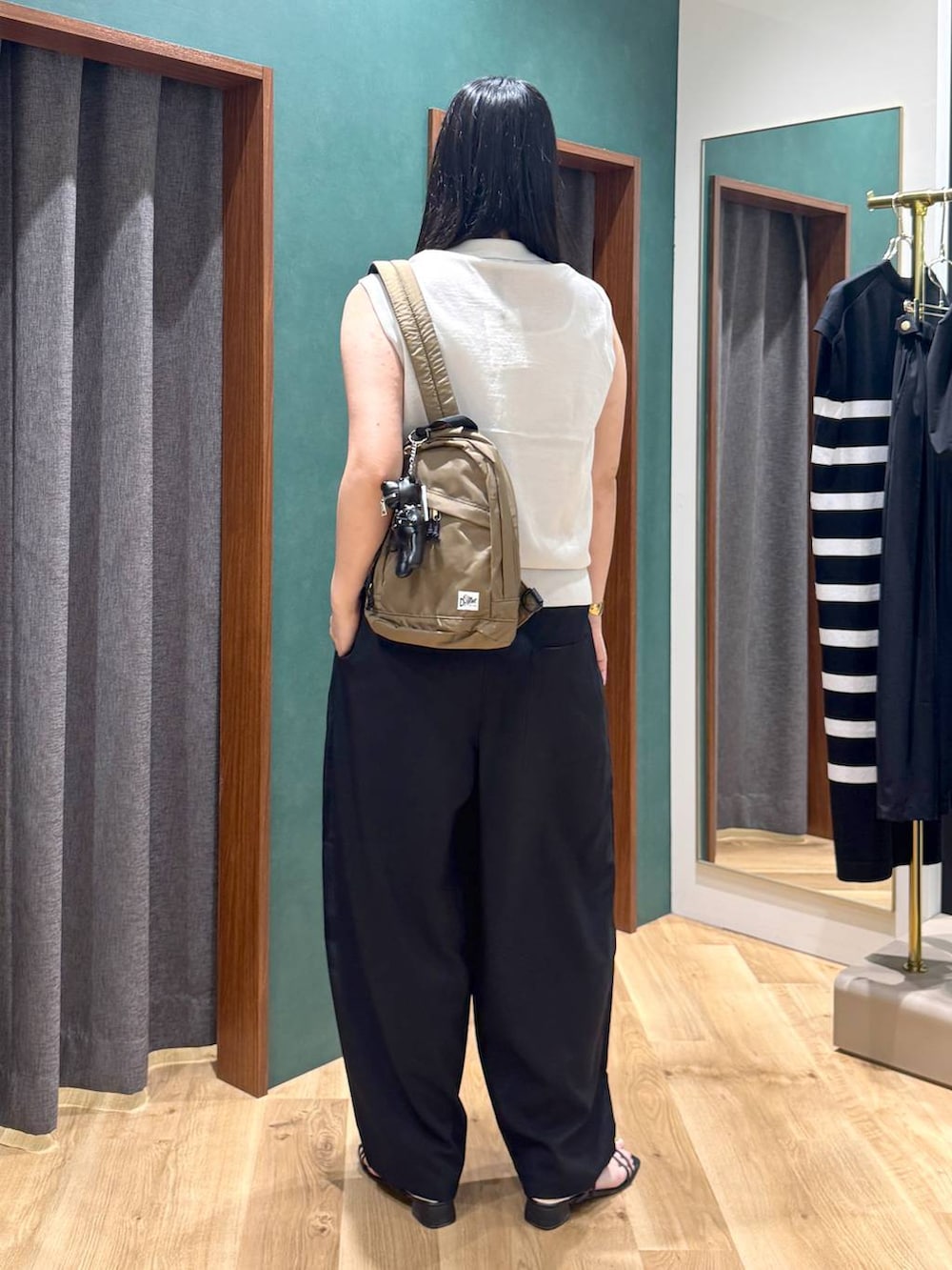 ブラック系のその他パンツ、グリーン系のバックパック/リュック、ベージュ系のベストを着用したレディースの春コーディネートの3枚目の写真