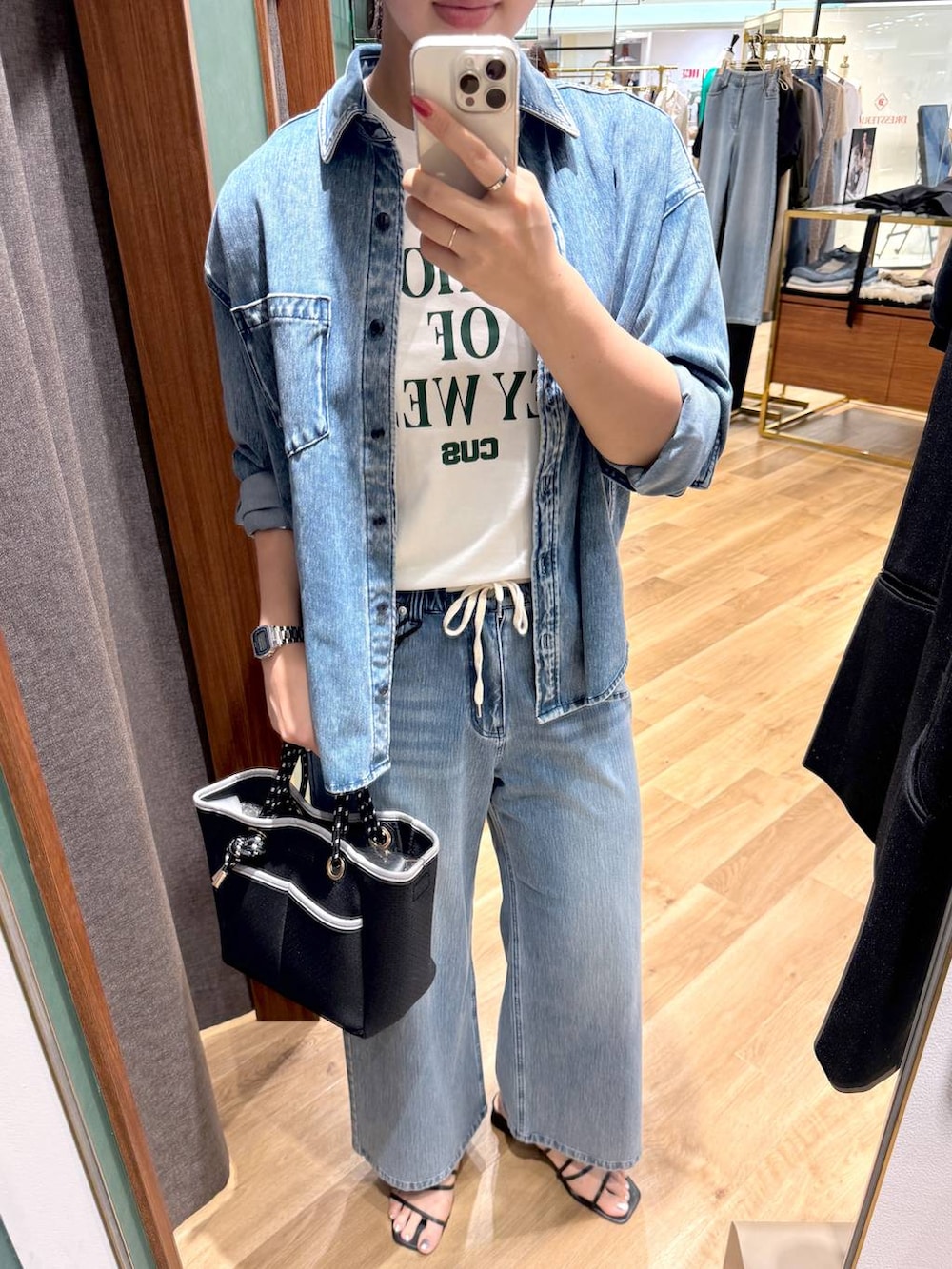 ブルー系のシャツ/ブラウス、ブルー系のデニムパンツ、ブラック系のトートバッグを着用したレディースの夏コーディネートの2枚目の写真