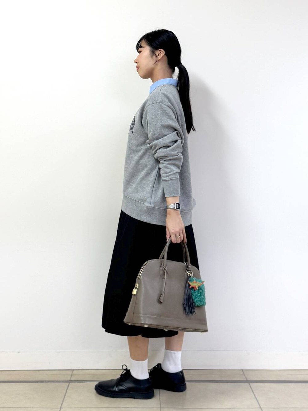 ブラック系のスカート、ブルー系のシャツ/ブラウス、グレー系のスウェットを着用したレディースの秋コーディネートの2枚目の写真
