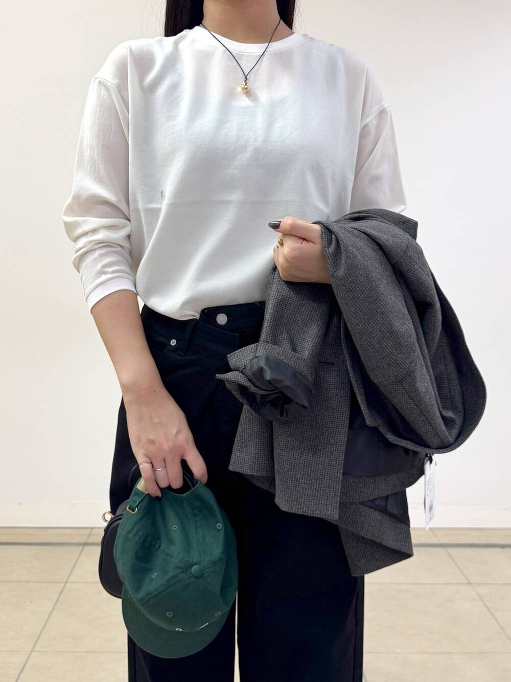 ブラック系のデニムパンツ、ブラウン系のテーラードジャケット、ブラック系のショルダーバッグを着用したレディースの秋コーディネートの5枚目の写真