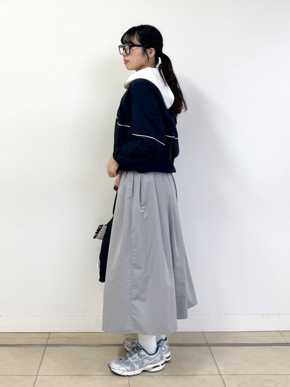 ブラック系のバックパック/リュック、ベージュ系のパーカー、グレー系のスカートを着用したレディースの冬コーディネートの2枚目の写真