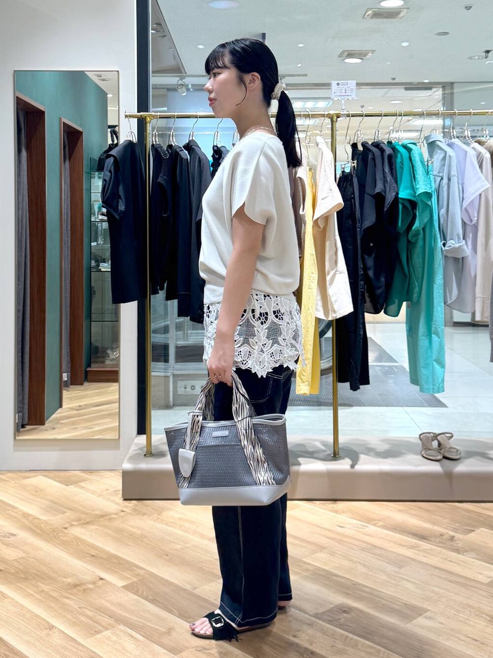ブラック系のトートバッグ、ブルー系のその他パンツ、ブラック系のサンダルを着用したレディースの夏コーディネートの2枚目の写真