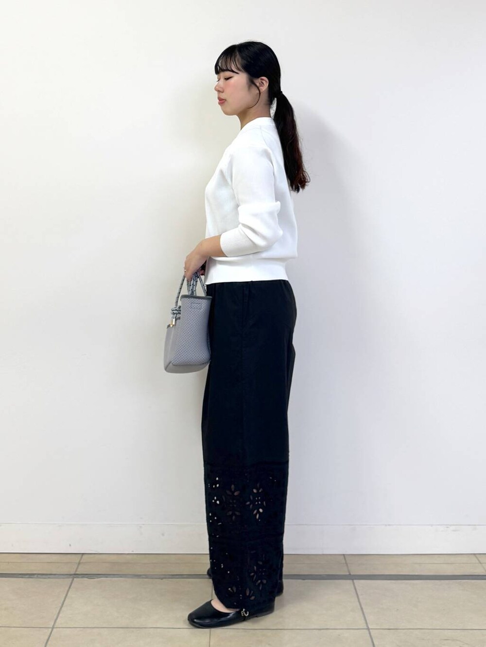 グレー系のタンクトップ、ブラック系のその他パンツ、グレー系のトートバッグを着用したレディースの春コーディネートの2枚目の写真