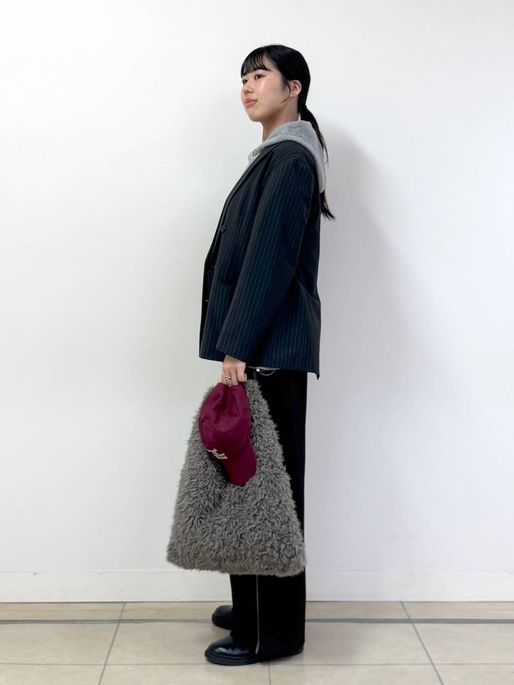 グレー系のテーラードジャケット、グレー系のパーカー、ブラック系のその他パンツを着用したレディースの秋コーディネートの2枚目の写真