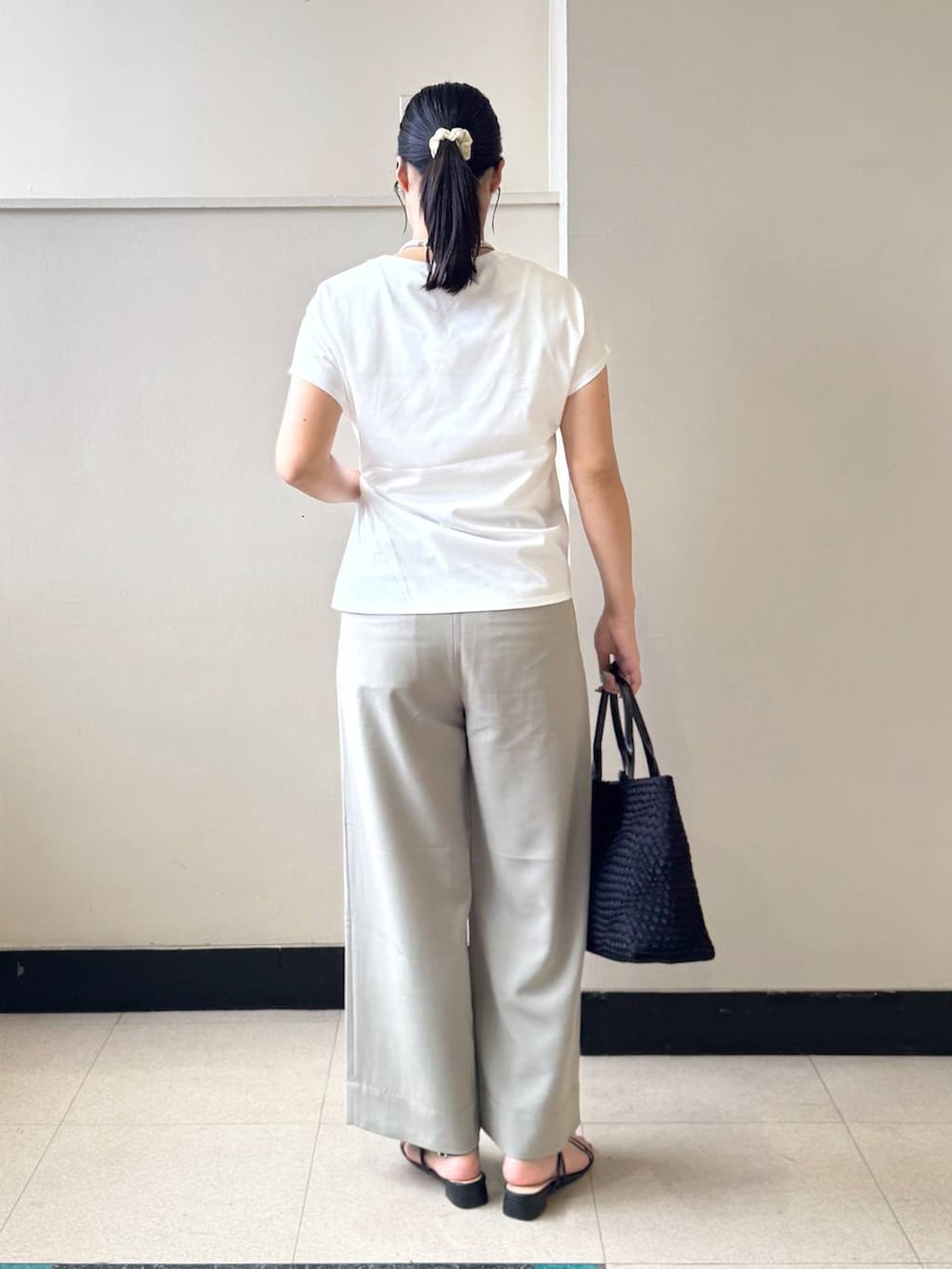 ブラック系のトートバッグ、ホワイト系のTシャツ/カットソー、ベージュ系のその他パンツを着用したレディースの夏コーディネートの3枚目の写真