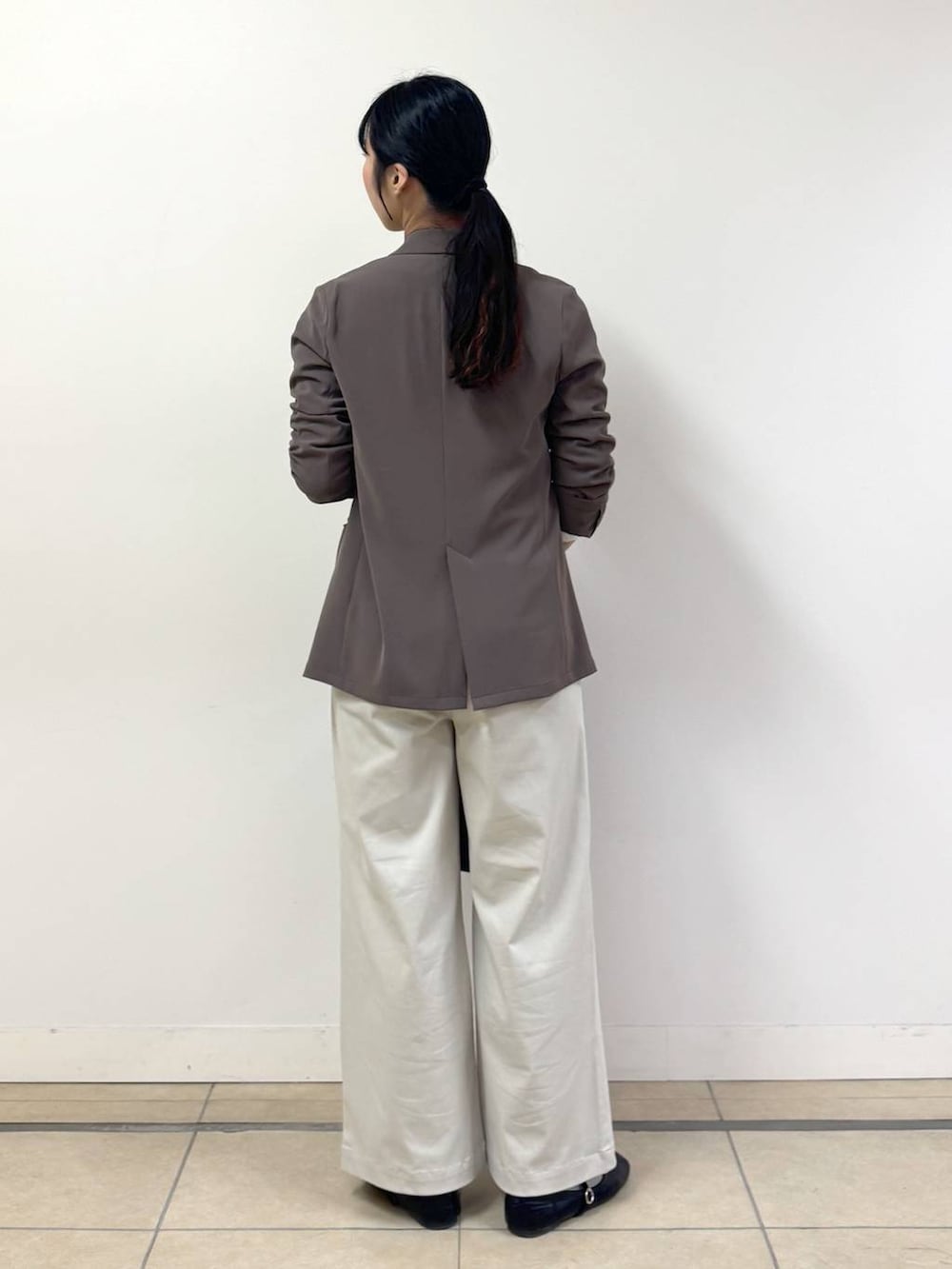 ブラック系のバックパック/リュック、ホワイト系のTシャツ/カットソー、ベージュ系のその他パンツを着用したレディースの冬コーディネートの3枚目の写真