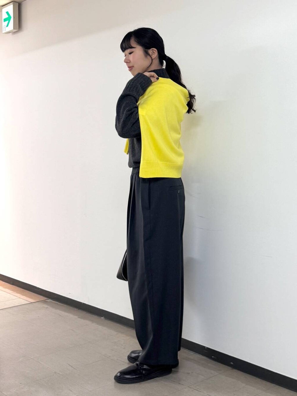 ブラック系のトートバッグ、グレー系のニット/セーター、グレー系のスラックスを着用したレディースの冬コーディネートの2枚目の写真