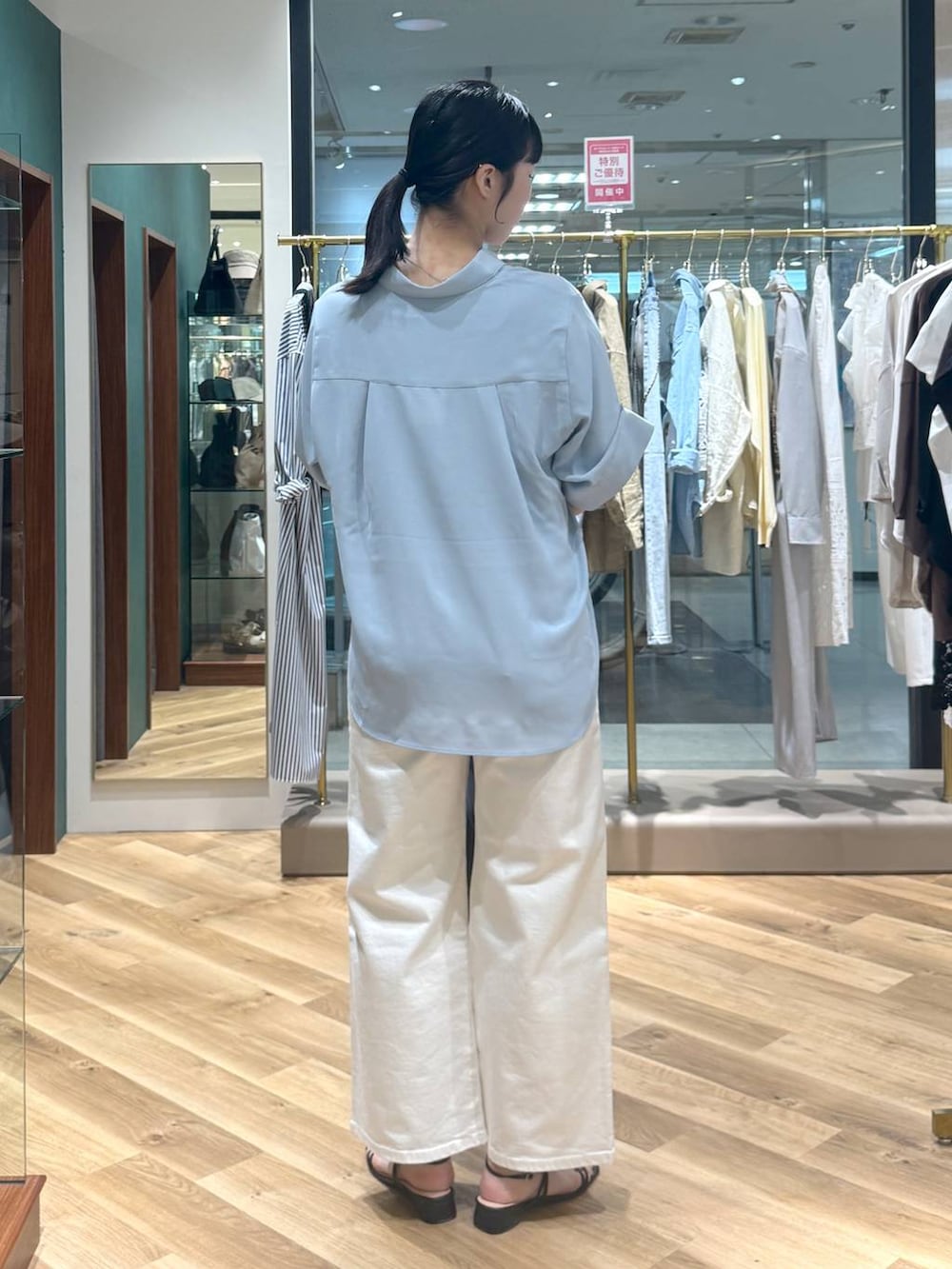 ホワイト系のデニムパンツ、グレー系のトートバッグ、ブルー系のシャツ/ブラウスを着用したレディースの春コーディネートの3枚目の写真