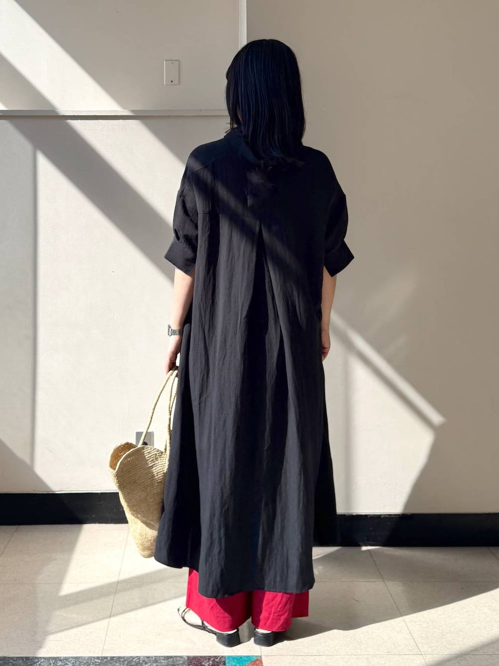 レッド系のその他パンツ、ブラック系のワンピース、ベージュ系のかごバッグを着用したレディースの春コーディネートの3枚目の写真