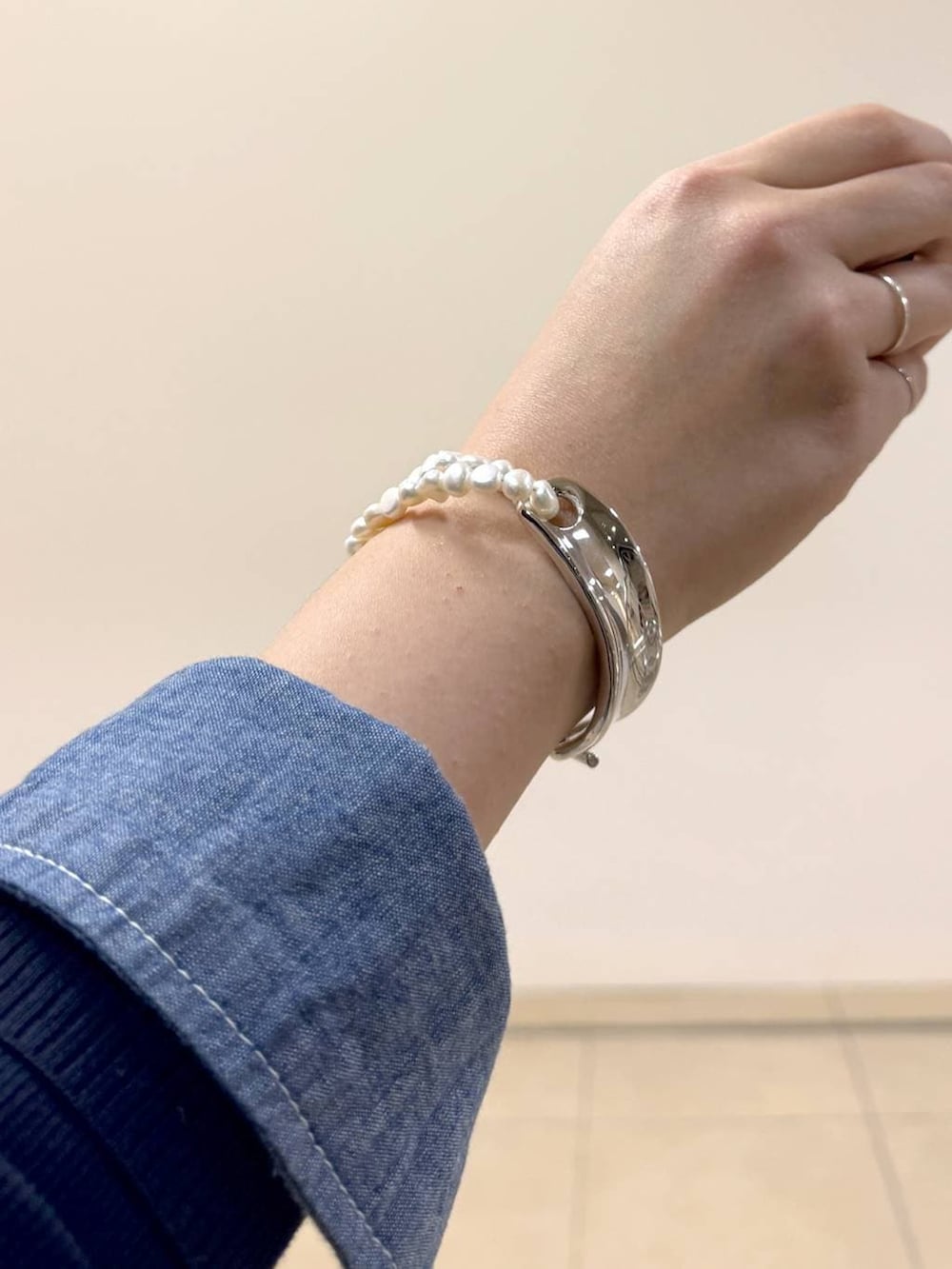 ブルー系のニット/セーター、ベージュ系のトートバッグ、ホワイト系のカーゴパンツを着用したレディースの冬コーディネートの4枚目の写真