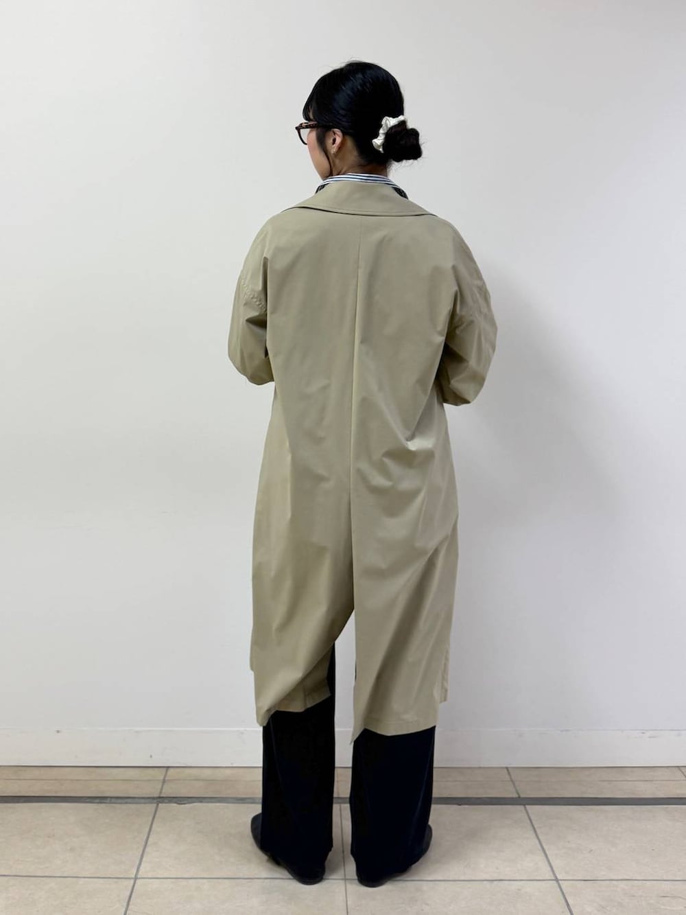 ブラック系のその他パンツ、ブルー系のシャツ/ブラウス、ベージュ系のステンカラーコートを着用したレディースの春コーディネートの3枚目の写真