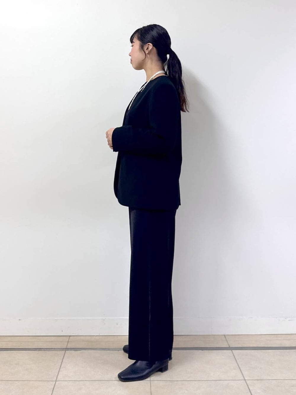 ブラック系のつなぎ/オールインワン、ブラック系のノーカラージャケット、その他のネックレスを着用したレディースの冬コーディネートの2枚目の写真