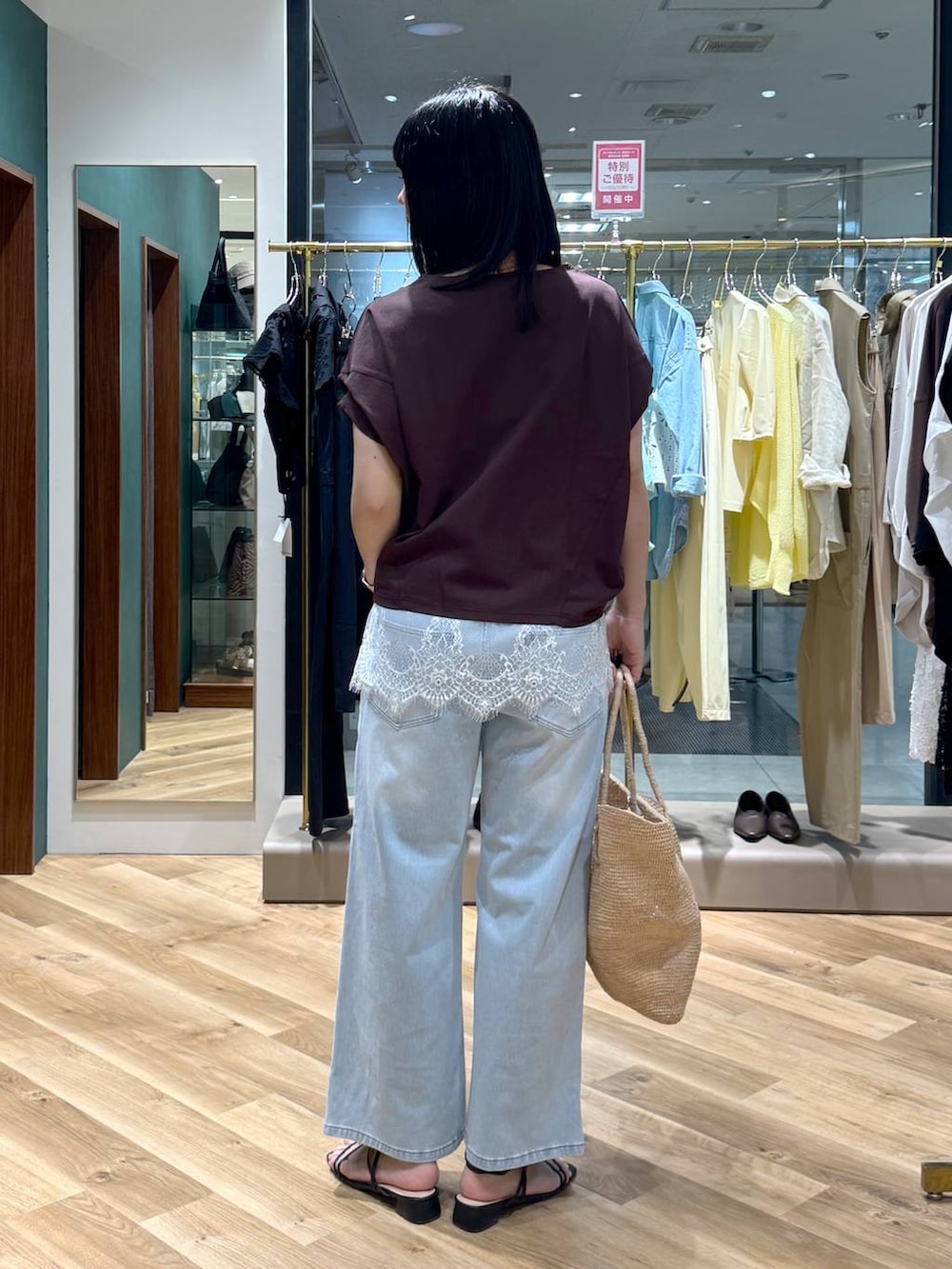 ブルー系のデニムパンツ、ブラウン系のTシャツ/カットソー、ホワイト系のキャミソールを着用したレディースの春コーディネートの3枚目の写真