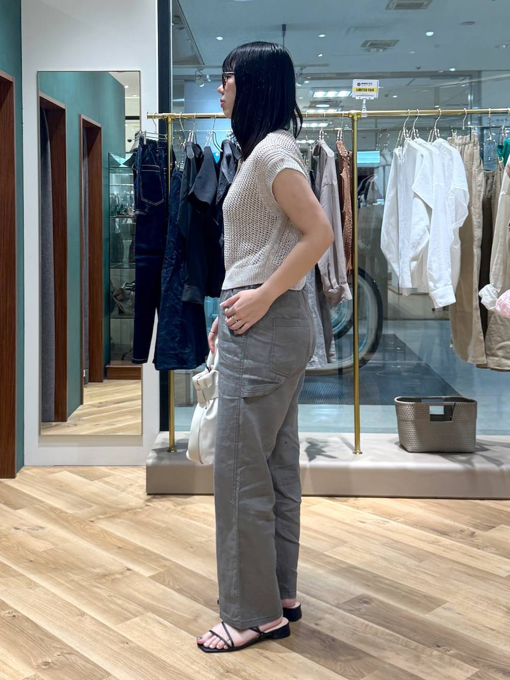 ホワイト系のショルダーバッグ、グレー系のその他パンツ、ベージュ系のニット/セーターを着用したレディースの夏コーディネートの2枚目の写真
