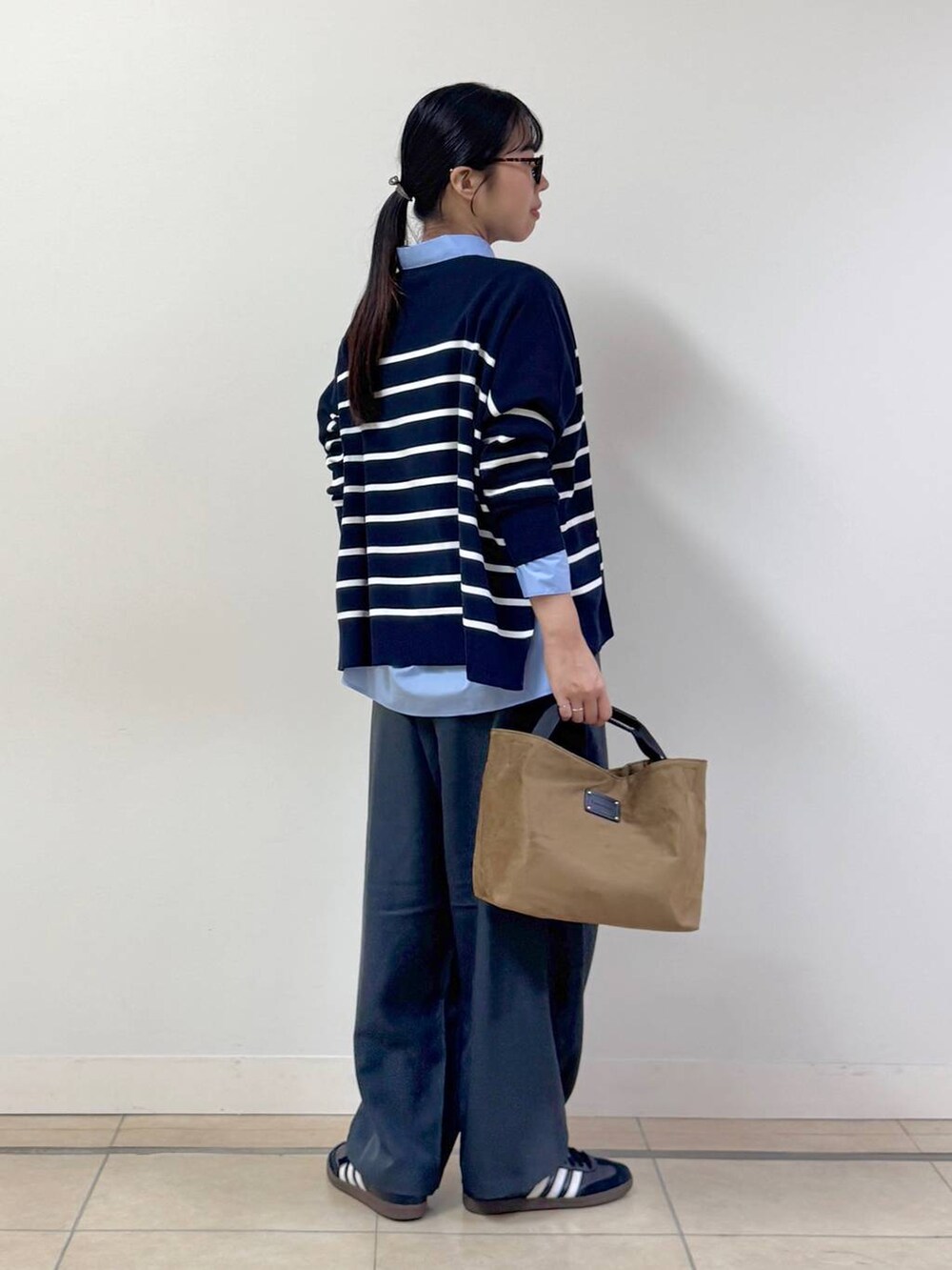 ブルー系のシャツ/ブラウス、グレー系のスラックス、イエロー系のトートバッグを着用したレディースの秋コーディネートの3枚目の写真