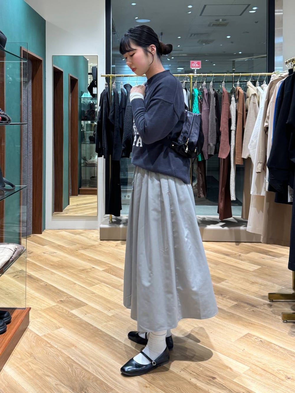 ホワイト系のTシャツ/カットソー、グレー系のニット/セーター、グレー系のスカートを着用したレディースの冬コーディネートの2枚目の写真