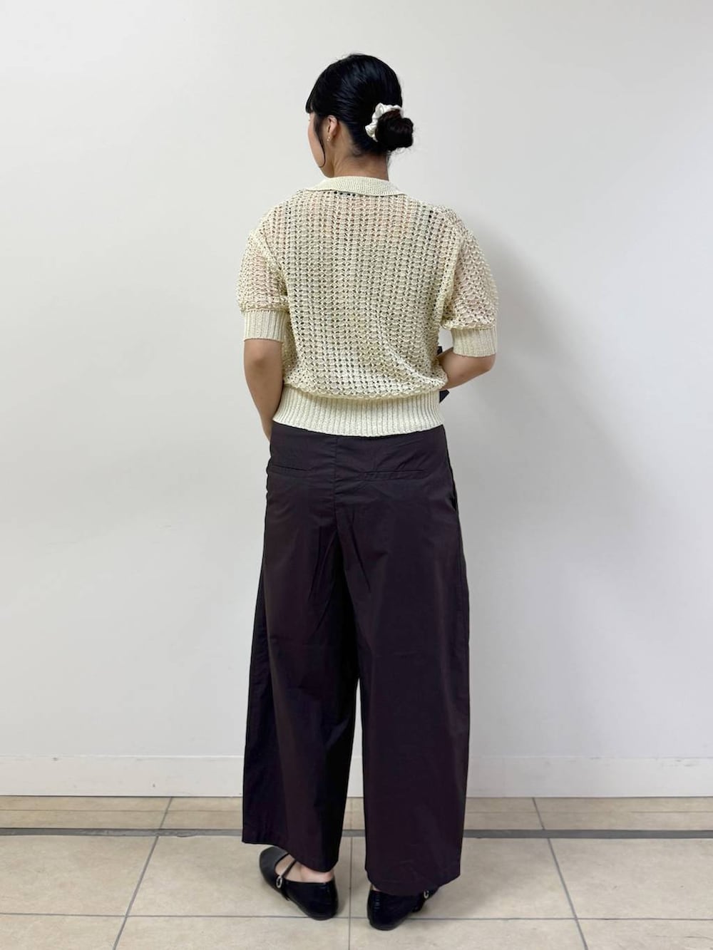 ブラウン系のその他パンツ、ベージュ系のタンクトップ、ホワイト系のニット/セーターを着用したレディースの春コーディネートの3枚目の写真