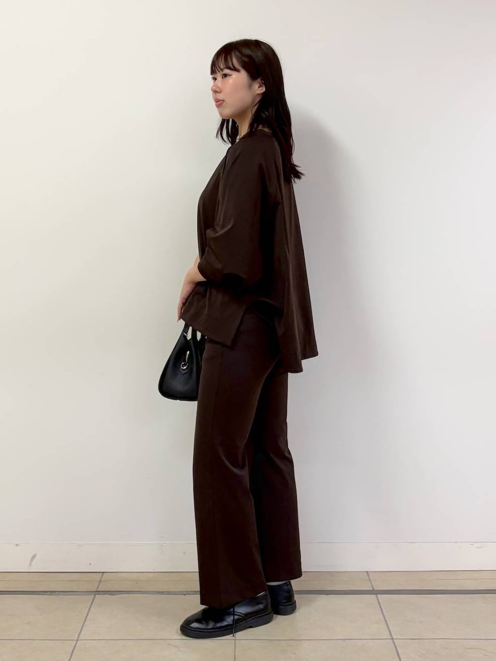 ブラック系のハンドバッグ、ブラウン系のTシャツ/カットソー、ブラウン系のその他パンツを着用したレディースの秋コーディネートの2枚目の写真