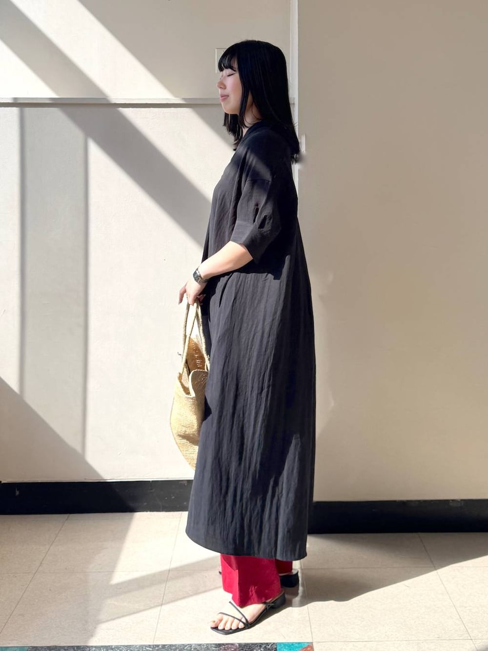 レッド系のその他パンツ、ブラック系のワンピース、ベージュ系のかごバッグを着用したレディースの春コーディネートの2枚目の写真
