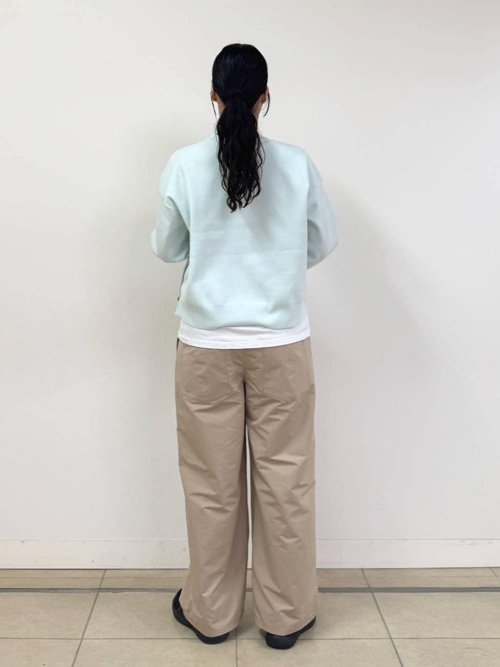 ブラウン系のショルダーバッグ、ブルー系のニット/セーター、ベージュ系のその他パンツを着用したレディースの冬コーディネートの3枚目の写真