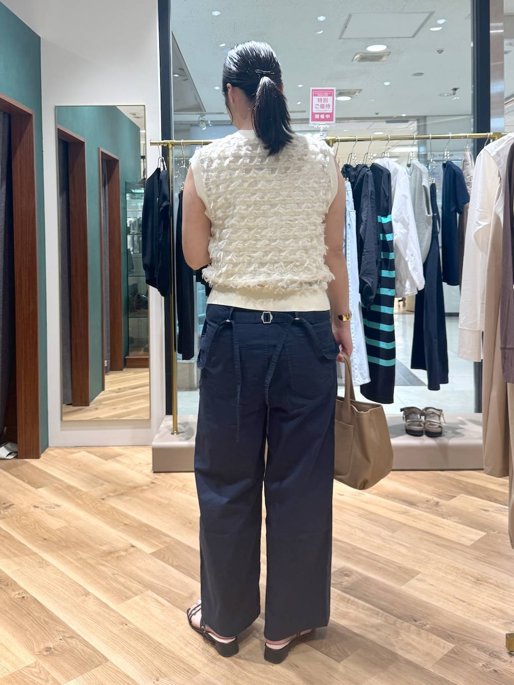 イエロー系のトートバッグ、ブルー系のその他パンツ、ホワイト系のニット/セーターを着用したレディースの春コーディネートの3枚目の写真