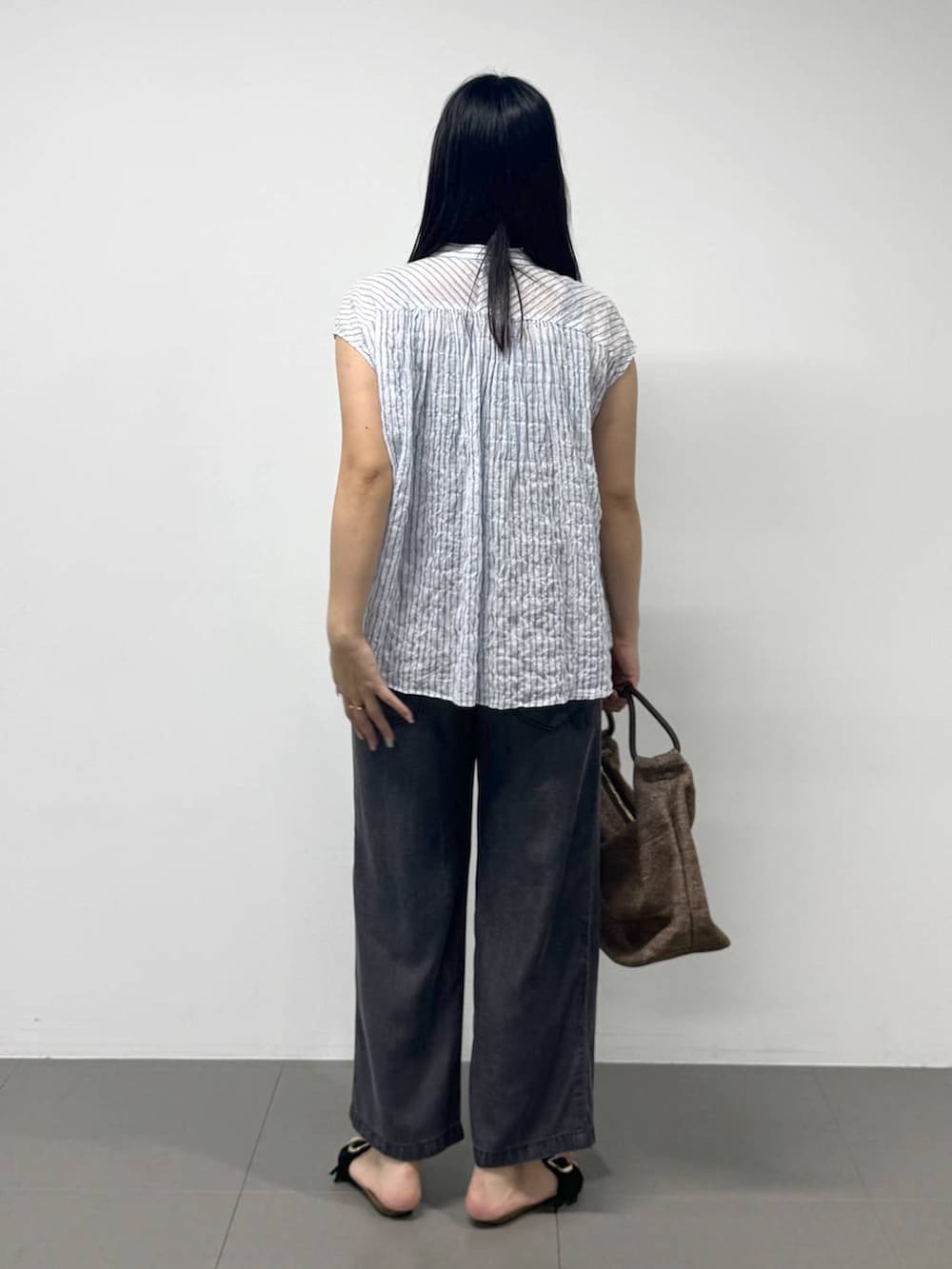 ブラック系のサンダル、ブルー系のシャツ/ブラウス、ブラック系のデニムパンツを着用したレディースの夏コーディネートの3枚目の写真