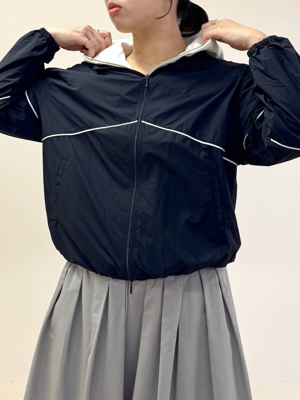 ブラック系のバックパック/リュック、ベージュ系のパーカー、グレー系のスカートを着用したレディースの冬コーディネートの3枚目の写真