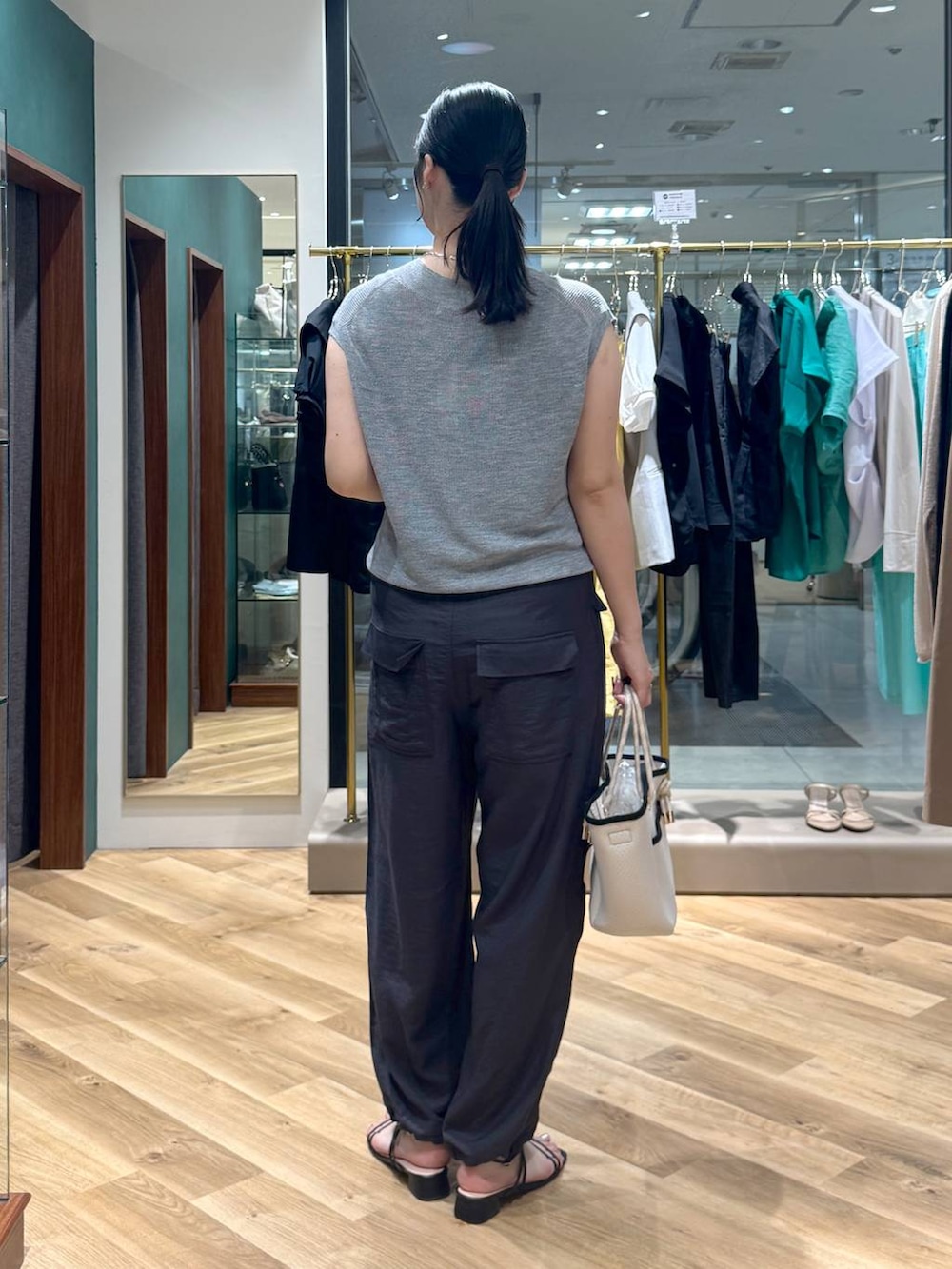 ホワイト系のトートバッグ、グレー系のベスト、グレー系のその他パンツを着用したレディースの夏コーディネートの3枚目の写真