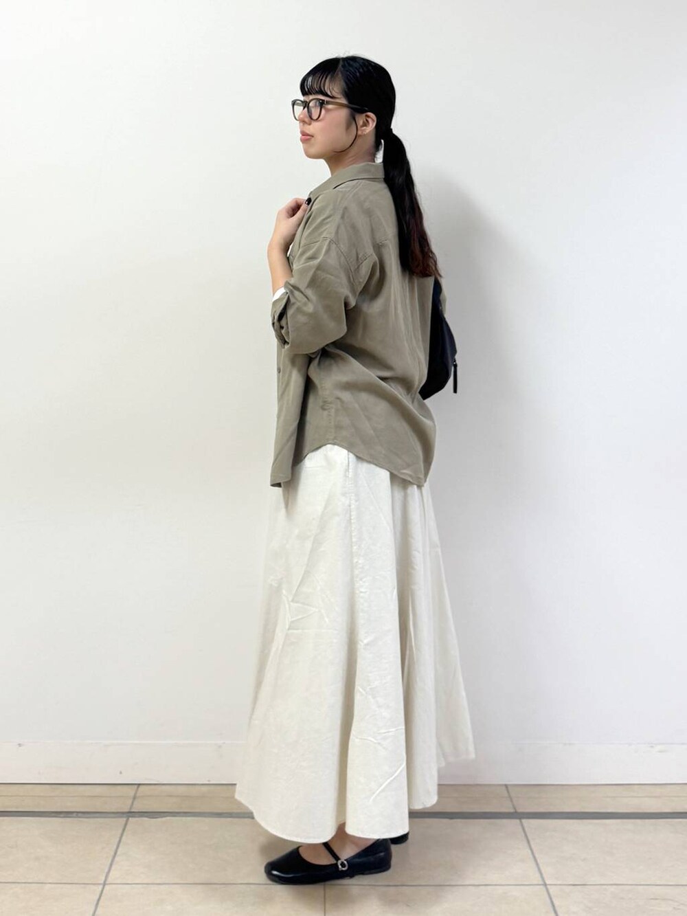 ホワイト系のTシャツ/カットソー、グリーン系のシャツ/ブラウス、ホワイト系のスカートを着用したレディースの春コーディネートの2枚目の写真