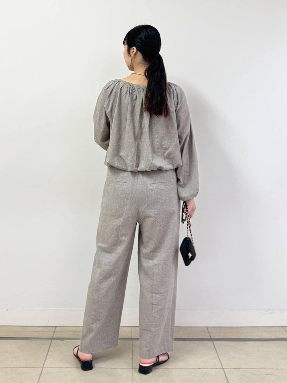 ベージュ系のシャツ/ブラウス、ベージュ系のその他パンツ、ブラック系のショルダーバッグを着用したレディースの春コーディネートの3枚目の写真