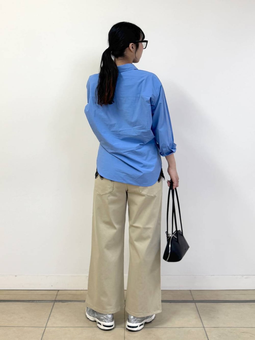 ベージュ系のデニムパンツ、ブルー系のシャツ/ブラウス、ブラック系のハンドバッグを着用したレディースの冬コーディネートの3枚目の写真