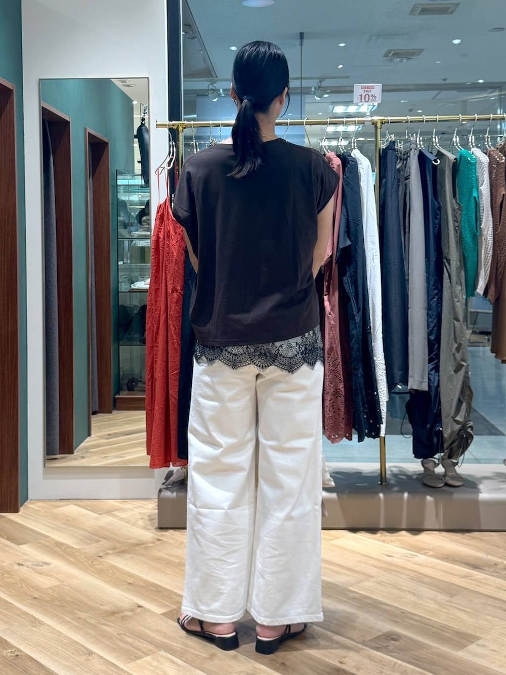 ブラウン系のTシャツ/カットソー、ホワイト系のデニムパンツ、ベージュ系のバックパック/リュックを着用したレディースの夏コーディネートの3枚目の写真