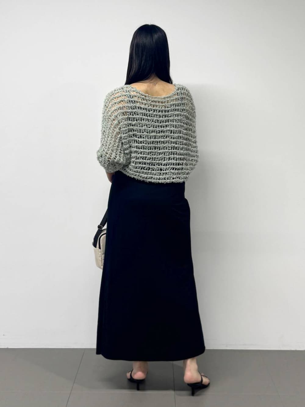 ブラック系のスリッポン、グレー系のタンクトップ、ホワイト系のショルダーバッグを着用したレディースの夏コーディネートの3枚目の写真