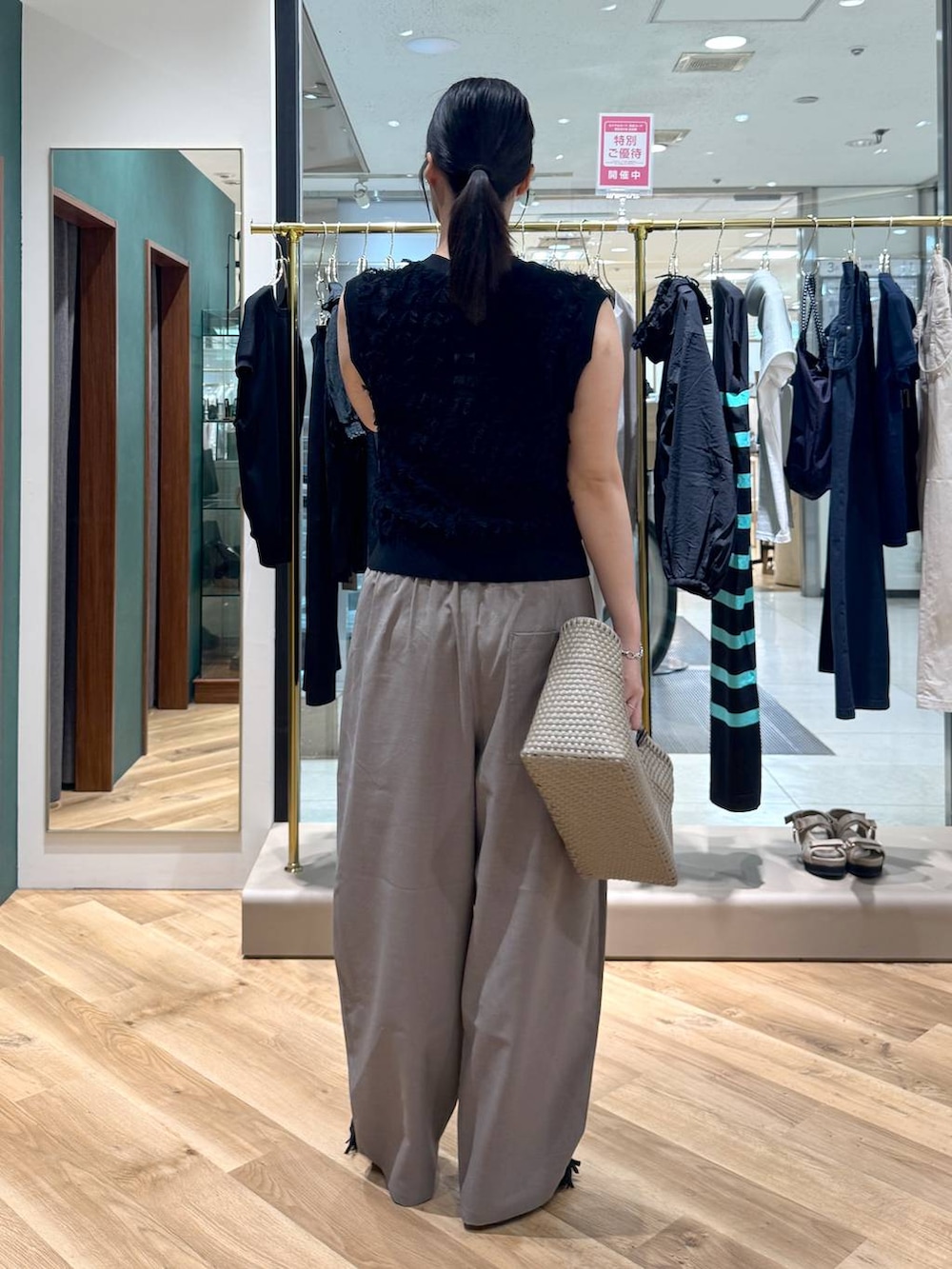 ブラウン系のその他パンツ、ブラック系のニット/セーター、ブラック系のサンダルを着用したレディースの春コーディネートの3枚目の写真