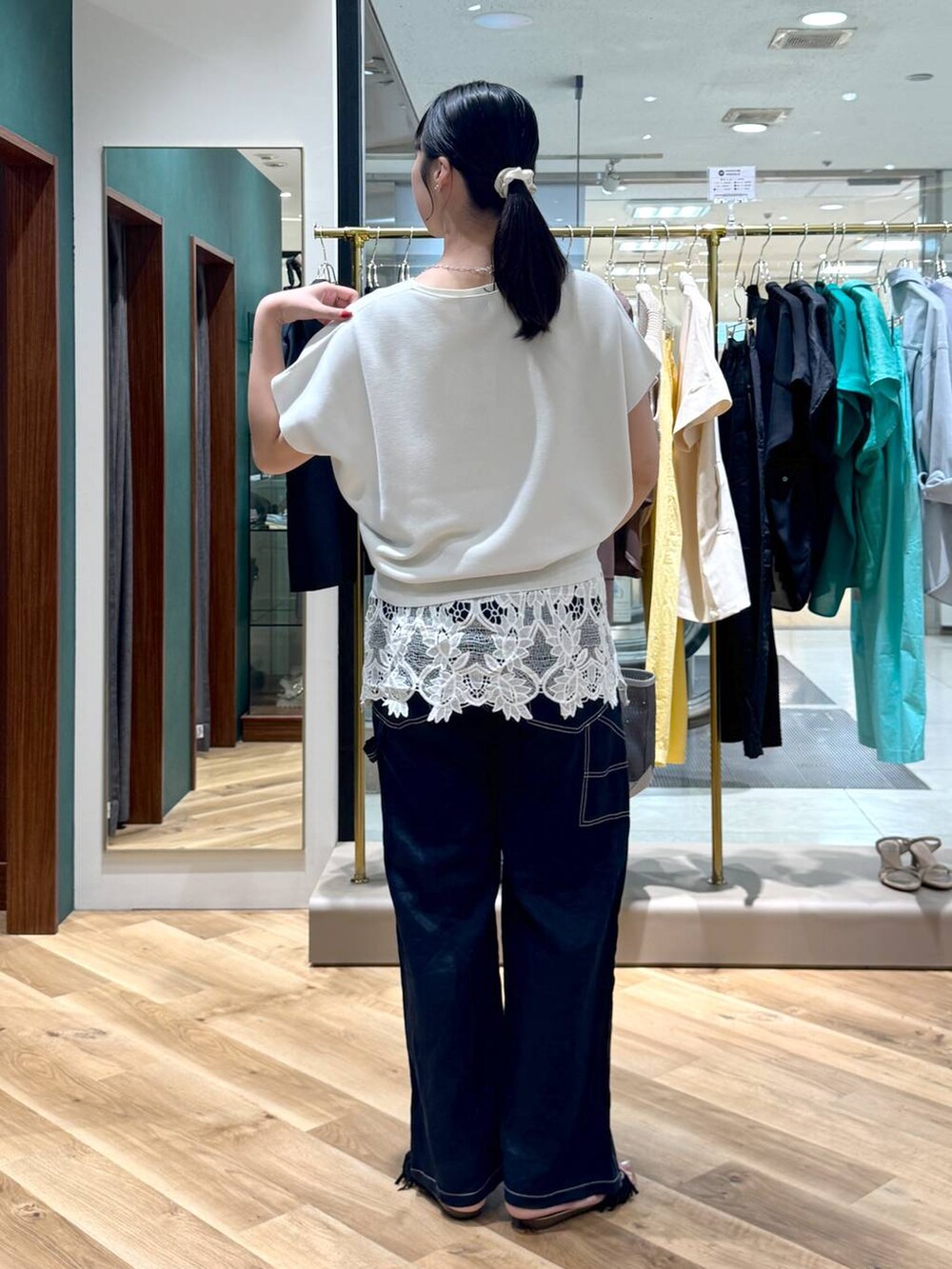 ブラック系のトートバッグ、ブルー系のその他パンツ、ブラック系のサンダルを着用したレディースの夏コーディネートの3枚目の写真