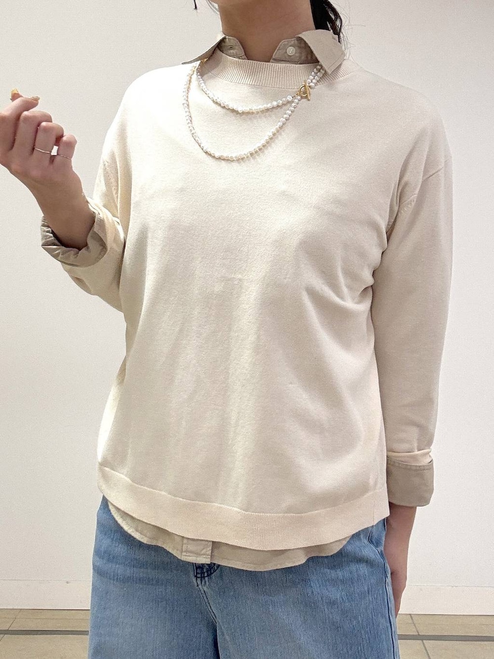 ブルー系のデニムパンツ、ベージュ系のシャツ/ブラウス、ホワイト系のニット/セーターを着用したレディースの冬コーディネートの4枚目の写真