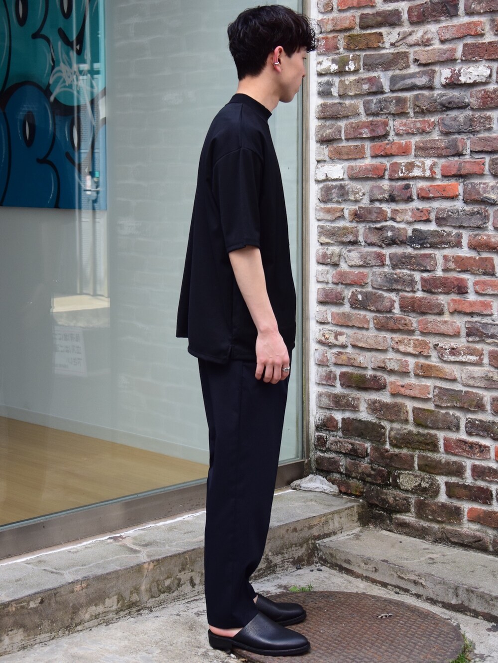 ブラック系のTシャツ/カットソーを着用したメンズの春コーディネートの3枚目の写真