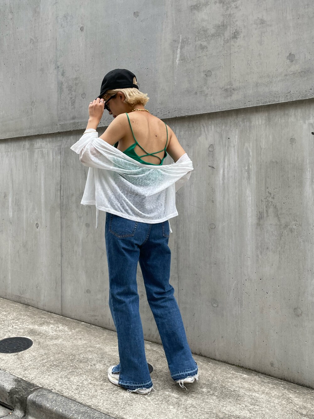 ホワイト系のカーディガン/ボレロ、グリーン系のキャミソール、ブラック系のキャップを着用したレディースの夏コーディネートの2枚目の写真