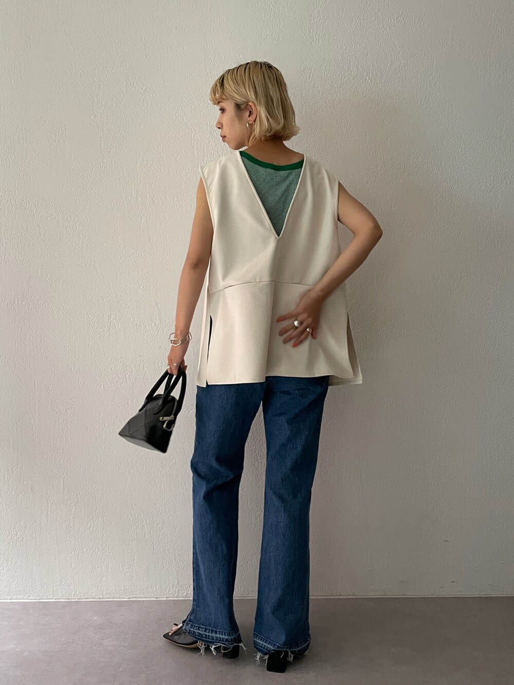 ホワイト系のベスト、グリーン系のタンクトップを着用したレディースの夏コーディネートの2枚目の写真