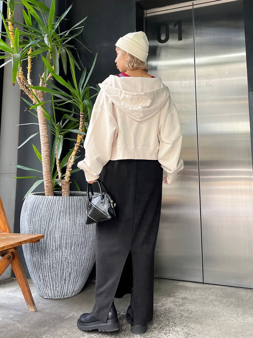 ホワイト系のパーカー、ブラック系のワンピース、ホワイト系のニットキャップ/ビーニーを着用したレディースの秋コーディネートの2枚目の写真