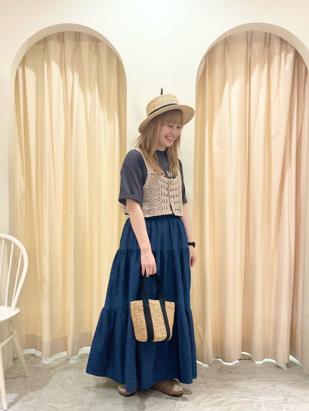 ブラック系のハンドバッグ、ベージュ系のベスト、グレー系のTシャツ/カットソーを着用したレディースの夏コーディネートの2枚目の写真