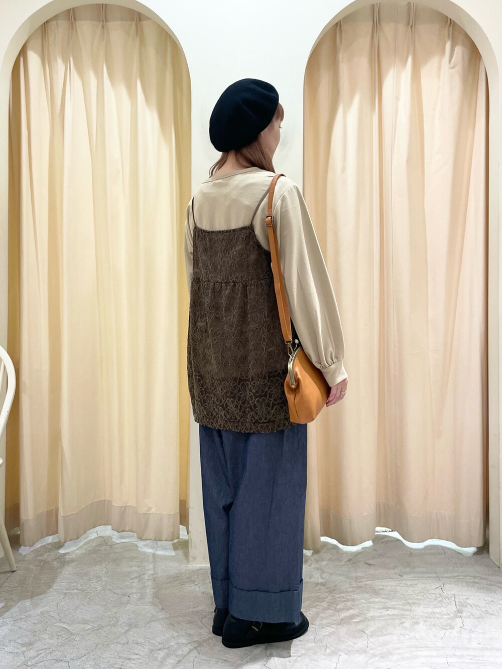 イエロー系のハンドバッグ、ブラック系のその他シューズ、ベージュ系のTシャツ/カットソーを着用したレディースの秋コーディネートの3枚目の写真