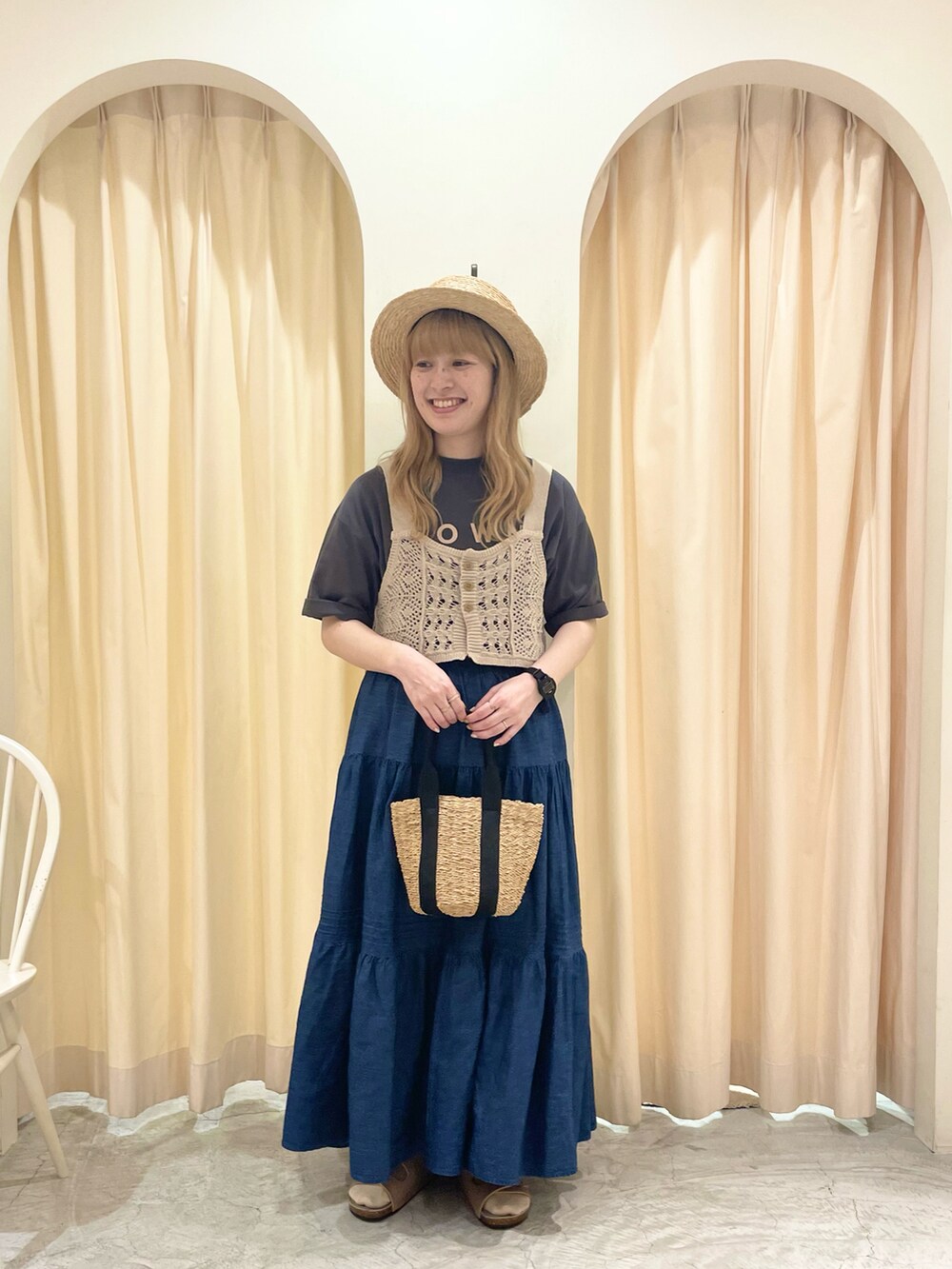 ブラック系のハンドバッグ、ベージュ系のベスト、グレー系のTシャツ/カットソーを着用したレディースの夏コーディネートの3枚目の写真