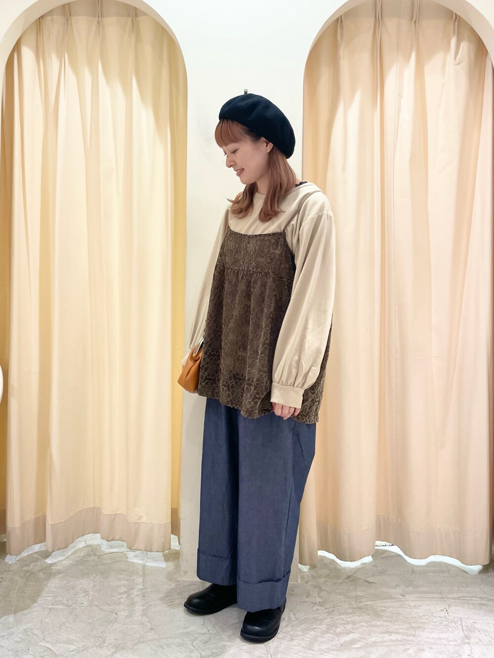 イエロー系のハンドバッグ、ブラック系のその他シューズ、ベージュ系のTシャツ/カットソーを着用したレディースの秋コーディネートの2枚目の写真