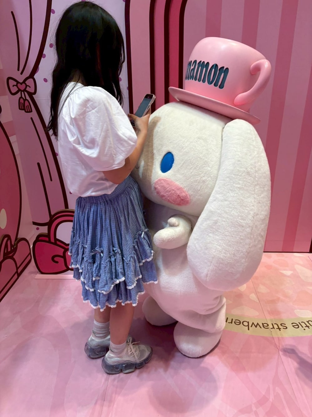 ブルー系のスカート、ブラック系のスニーカー、ホワイト系のTシャツ/カットソーを着用したレディースの秋コーディネートの2枚目の写真