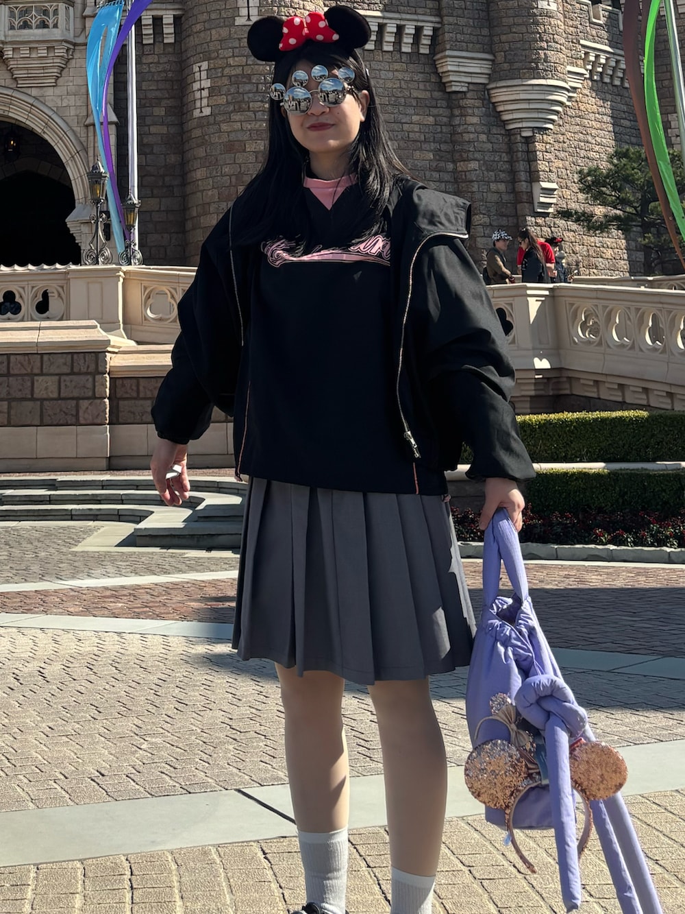 グレー系のスカート、ブラック系のTシャツ/カットソー、ブラック系のスニーカーを着用したレディースの春コーディネートの2枚目の写真